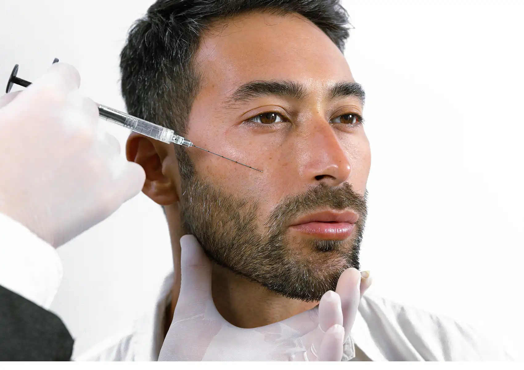 A doctor injecting dermal filler into a male patient's cheek at Anaya Aesthetics clinic in Kerobokan, Bali. 