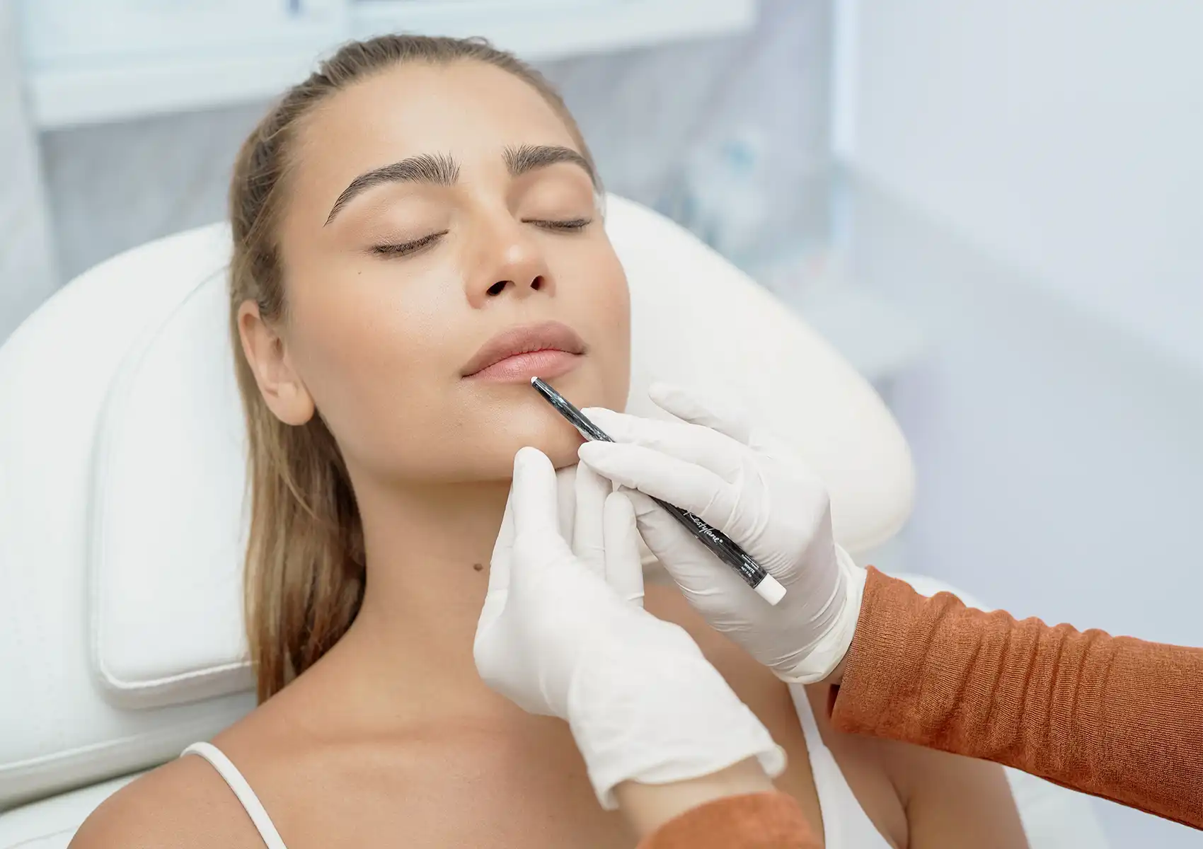An aesthetic doctor marking a patient's chin and jawline before injecting dermal fillers to define facial features at Anaya Aesthetics in Bali. 